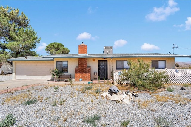 15761 Joshua Rd, Apple Valley, CA 92307 - ranch-style home with stucco siding, a chimney, driveway, and a garage
