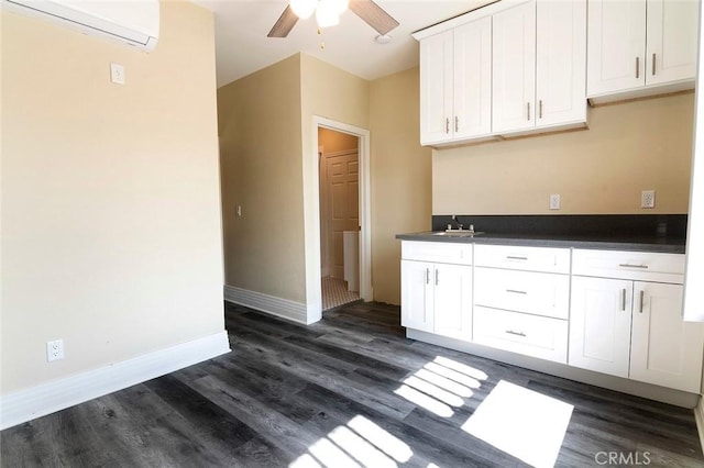 1703 Toberman St, Los Angeles, CA 90015 - kitchen with a wall unit AC, dark countertops, a ceiling fan, dark wood-style floors, and white cabinetry