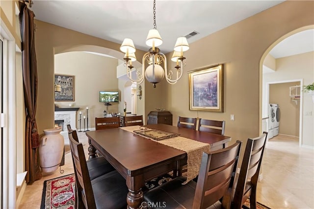 71 Via Barcaza, Coto De Caza, CA 92679 - dining space with arched walkways, separate washer and dryer, light tile patterned flooring, and a lit fireplace