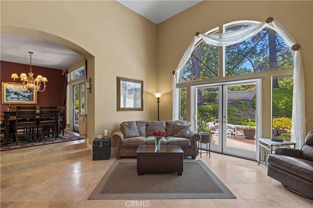 71 Via Barcaza, Coto De Caza, CA 92679 - tiled living area featuring a chandelier, arched walkways, healthy amount of natural light, a towering ceiling, and french doors
