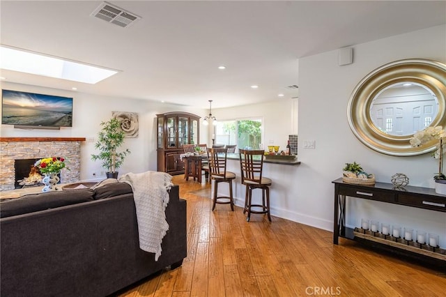 8042 Driftwood Dr, Huntington Beach, CA 92646 - living area with hardwood / wood-style flooring, a stone fireplace, a skylight, and recessed lighting
