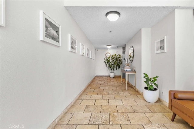 4210 Via Arbolada Unit 317, Los Angeles, CA 90042 - corridor featuring stone tile floors and a textured ceiling