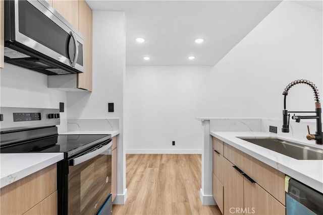 4210 Via Arbolada Unit 317, Los Angeles, CA 90042 - kitchen with appliances with stainless steel finishes, light brown cabinetry, light wood-style floors, modern cabinets, and recessed lighting