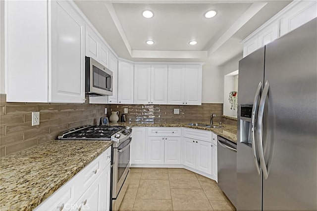 4004 Polk Ct, Chino, CA 91710 - kitchen with appliances with stainless steel finishes, a tray ceiling, white cabinetry, decorative backsplash, and recessed lighting