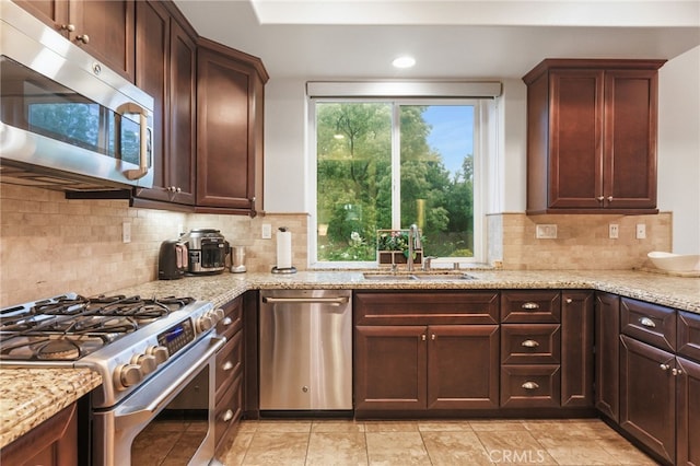 18141 Topham St, Tarzana, CA 91335 - kitchen featuring stainless steel appliances, light stone counters, backsplash, light tile patterned floors, and dark brown cabinetry