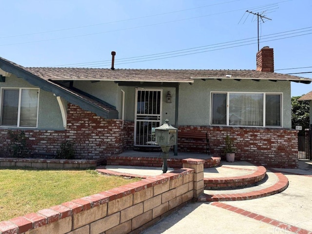 14502 Sabine Dr, La Mirada, CA 90638 - view of front of house with stucco siding, a chimney, a front yard, and brick siding