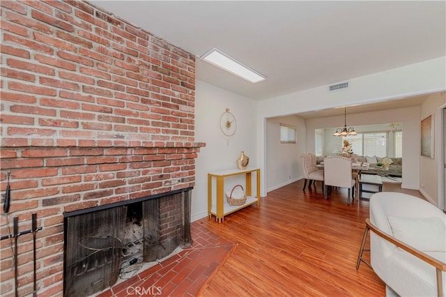 405 W Virginia Ave, Glendora, CA 91741 - living area featuring a fireplace, wood finished floors, and a chandelier