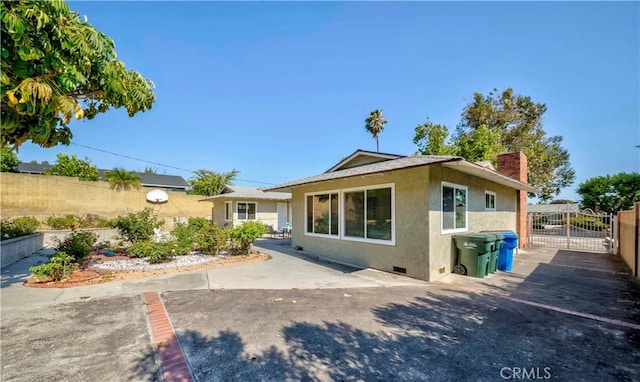 405 W Virginia Ave, Glendora, CA 91741 - back of property with stucco siding, crawl space, a chimney, and a gate
