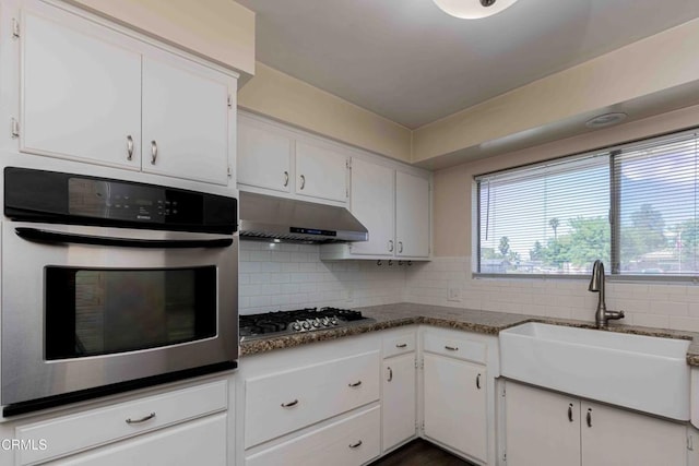 6000 Eugene Pl, Bakersfield, CA 93308 - kitchen featuring appliances with stainless steel finishes, under cabinet range hood, white cabinetry, and backsplash
