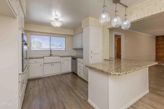 6000 Eugene Pl, Bakersfield, CA 93308 - kitchen with a peninsula, dark wood-type flooring, appliances with stainless steel finishes, decorative backsplash, and white cabinetry