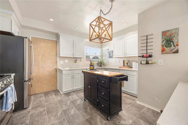 1642 W Woodcrest Ave, Fullerton, CA 92833 - kitchen featuring a chandelier, stainless steel range with gas cooktop, light countertops, white cabinets, and dark cabinets