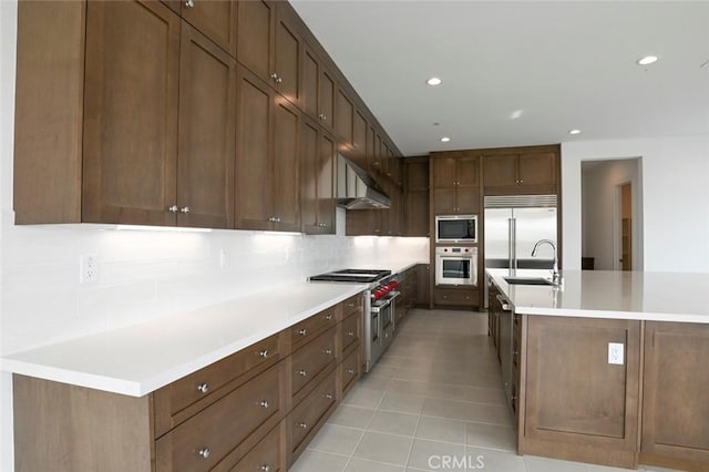 20552 Edgewood Ct, Chatsworth, CA 91311 - kitchen featuring built in appliances, tasteful backsplash, light tile patterned floors, light countertops, and ventilation hood