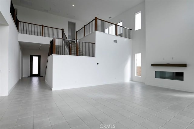 20552 Edgewood Ct, Chatsworth, CA 91311 - unfurnished living room featuring a high ceiling, tile patterned floors, plenty of natural light, and stairs