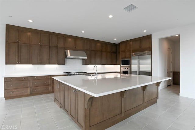 20552 Edgewood Ct, Chatsworth, CA 91311 - kitchen with built in appliances, ventilation hood, light tile patterned floors, recessed lighting, and light countertops