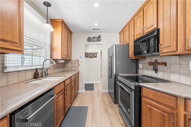 20322 Cantara St, Winnetka, CA 91306 - kitchen with stainless steel appliances, tasteful backsplash, decorative light fixtures, light wood finished floors, and brown cabinets