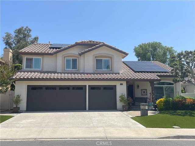 17 Thornbird, Aliso Viejo, CA 92656 - mediterranean / spanish house featuring an attached garage, roof mounted solar panels, stucco siding, concrete driveway, and a tiled roof