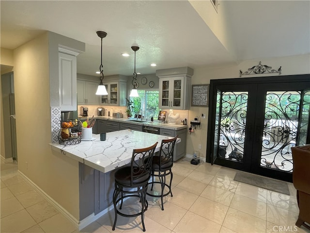 17 Thornbird, Aliso Viejo, CA 92656 - kitchen with a peninsula, a breakfast bar, tasteful backsplash, glass insert cabinets, and recessed lighting