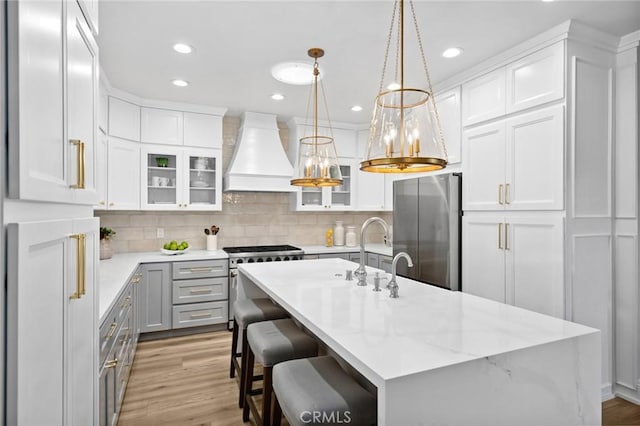362 Vista Madera, Newport Beach, CA 92660 - kitchen with appliances with stainless steel finishes, custom exhaust hood, gray cabinetry, light wood-style flooring, and tasteful backsplash