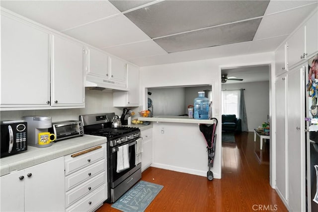 4220 W 165th St, Lawndale, CA 90260 - kitchen with gas stove, under cabinet range hood, black microwave, tile countertops, and dark wood finished floors