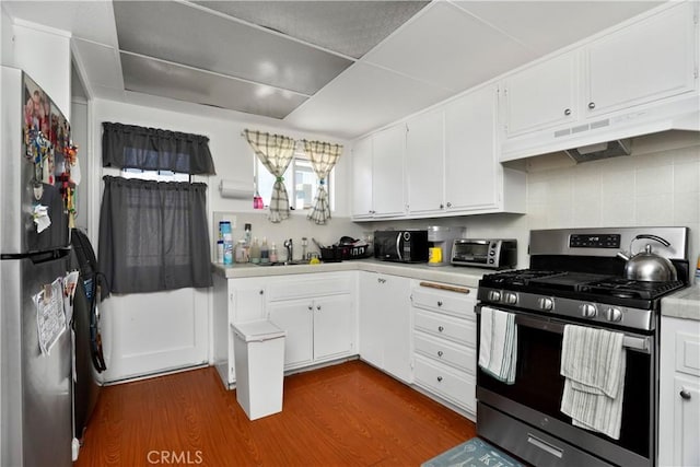 4220 W 165th St, Lawndale, CA 90260 - kitchen with appliances with stainless steel finishes, under cabinet range hood, light countertops, tasteful backsplash, and dark wood finished floors