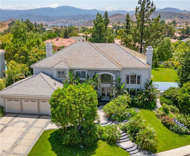 25448 Cumberland Ln, Calabasas, CA 91302 - view of front of property with a chimney, french doors, a tiled roof, stucco siding, and concrete driveway