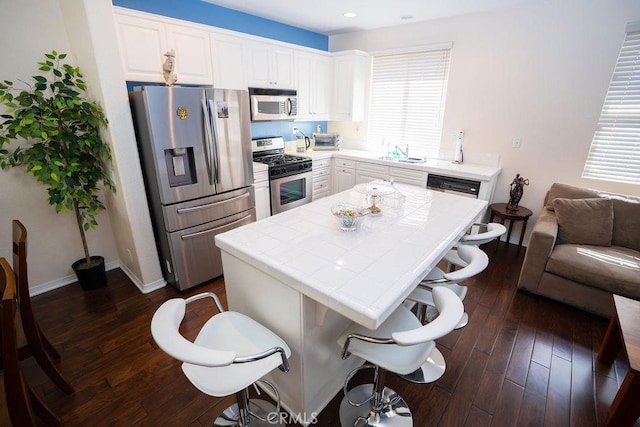 159 Principia Ct, Claremont, CA 91711 - kitchen featuring appliances with stainless steel finishes, tile countertops, a kitchen island, and dark wood-type flooring
