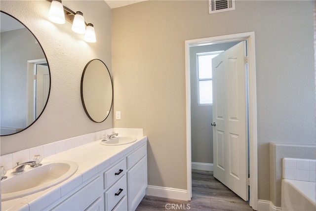 41808 Vardon Dr, Temecula, CA 92591 - bathroom featuring double vanity, wood finished floors, and a bath