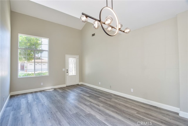 41808 Vardon Dr, Temecula, CA 92591 - unfurnished room with a chandelier, plenty of natural light, high vaulted ceiling, and wood finished floors
