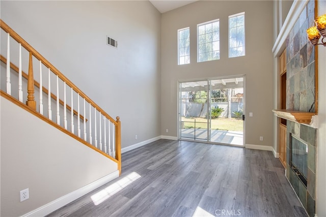 41808 Vardon Dr, Temecula, CA 92591 - unfurnished living room with dark wood finished floors, a tiled fireplace, stairway, and a towering ceiling
