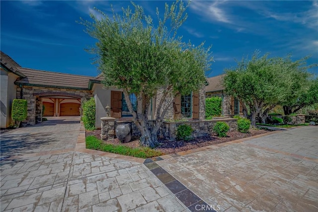 2882 Trovare Ct, Merced, CA 95340 - view of front of home featuring stone siding, driveway, stucco siding, a tiled roof, and a garage