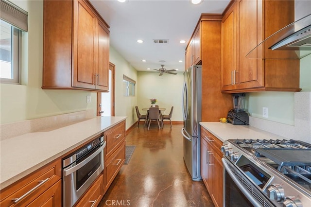 4510 S Mullen Ave, View Park, CA 90043 - kitchen with stainless steel appliances, wall chimney exhaust hood, recessed lighting, concrete floors, and brown cabinetry