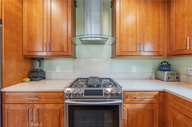4510 S Mullen Ave, View Park, CA 90043 - kitchen featuring wall chimney exhaust hood, stainless steel range with gas cooktop, light countertops, and brown cabinetry