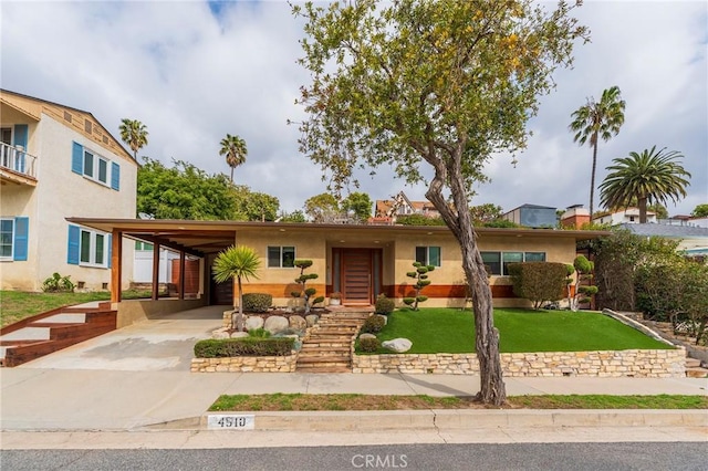 4510 S Mullen Ave, View Park, CA 90043 - view of front of house featuring concrete driveway, stucco siding, a front yard, and a carport