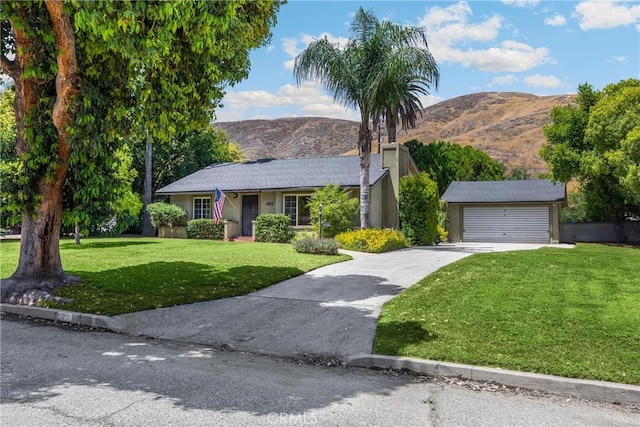 1210 W Marshall Blvd, San Bernardino, CA 92405 - single story home with a front yard, a mountain view, concrete driveway, and an outbuilding