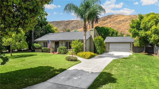 1210 W Marshall Blvd, San Bernardino, CA 92405 - view of front of home featuring a mountain view, an outbuilding, stucco siding, and driveway