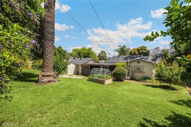 1210 W Marshall Blvd, San Bernardino, CA 92405 - back of property featuring a lawn, a storage unit, and a garden