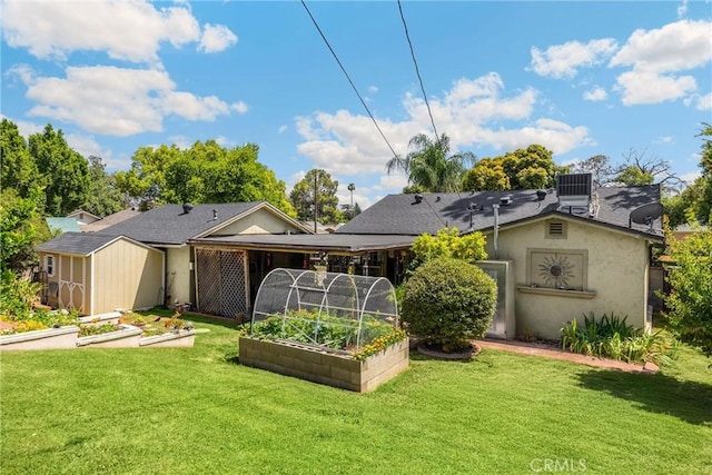 1210 W Marshall Blvd, San Bernardino, CA 92405 - rear view of house with a vegetable garden, a storage shed, a yard, and stucco siding