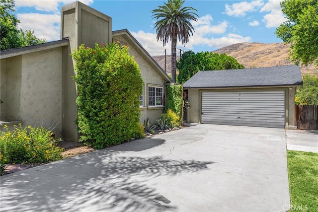1210 W Marshall Blvd, San Bernardino, CA 92405 - view of side of home featuring a mountain view, stucco siding, and a garage