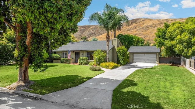 1210 W Marshall Blvd, San Bernardino, CA 92405 - view of front of home featuring a mountain view, driveway, a garage, a chimney, and an outdoor structure