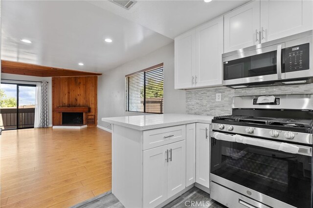 2621 E 20th St Unit 12, Signal Hill, CA 90755 - kitchen featuring appliances with stainless steel finishes, recessed lighting, healthy amount of natural light, a peninsula, and tasteful backsplash