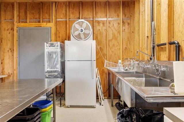 4742 Crow Rd, Oakdale, CA 95361 - kitchen with freestanding refrigerator, brown cabinetry, and wooden walls