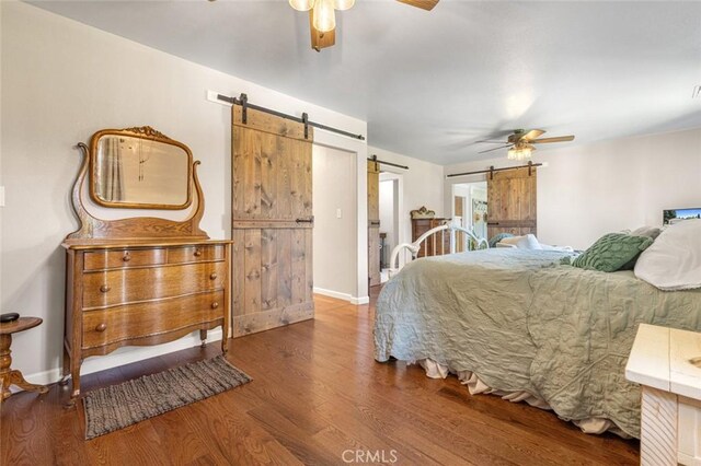 4742 Crow Rd, Oakdale, CA 95361 - bedroom with a barn door, wood finished floors, and a ceiling fan