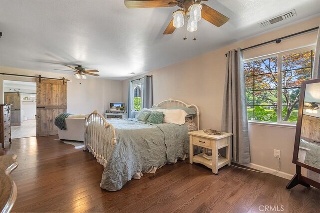 4742 Crow Rd, Oakdale, CA 95361 - bedroom with a barn door, wood finished floors, and ceiling fan