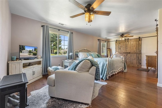 4742 Crow Rd, Oakdale, CA 95361 - bedroom with a barn door, dark wood-type flooring, and ceiling fan