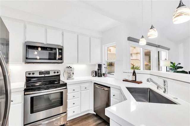 2 Daytona Unit 129, Laguna Niguel, CA 92677 - kitchen featuring stainless steel appliances, light countertops, white cabinetry, and decorative light fixtures
