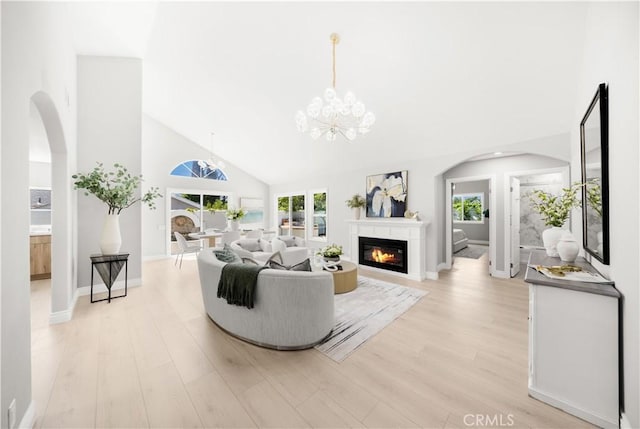 25981 Cordillera Dr, Mission Viejo, CA 92691 - living room with high vaulted ceiling, light wood-style floors, a glass covered fireplace, arched walkways, and a chandelier