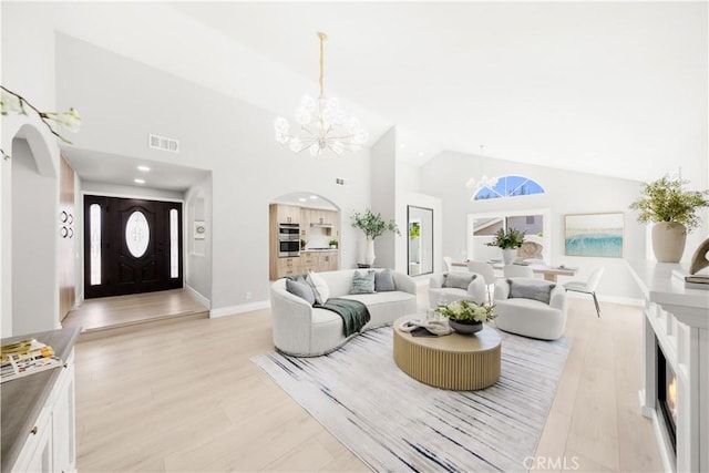25981 Cordillera Dr, Mission Viejo, CA 92691 - living area with a chandelier, high vaulted ceiling, arched walkways, and light wood-type flooring