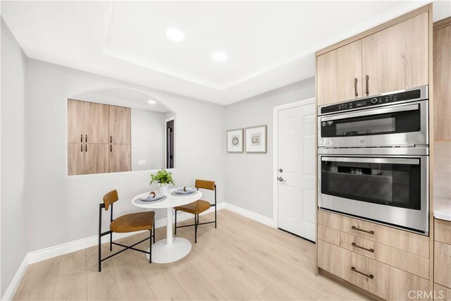 25981 Cordillera Dr, Mission Viejo, CA 92691 - kitchen featuring light brown cabinetry, double oven, arched walkways, light wood finished floors, and recessed lighting