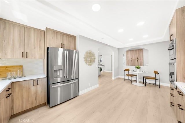 25981 Cordillera Dr, Mission Viejo, CA 92691 - kitchen featuring stainless steel fridge with ice dispenser, light brown cabinets, arched walkways, light countertops, and decorative backsplash