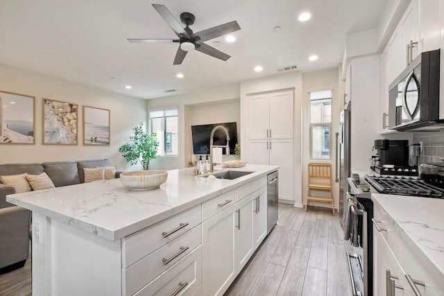 1201 Via Lucero, Oceanside, CA 92056 - kitchen with appliances with stainless steel finishes, open floor plan, white cabinetry, light stone countertops, and recessed lighting